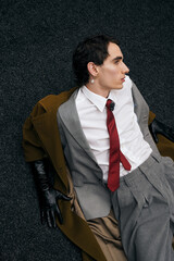 Stylish man lounging effortlessly in a chic urban setting with bold fashion choices