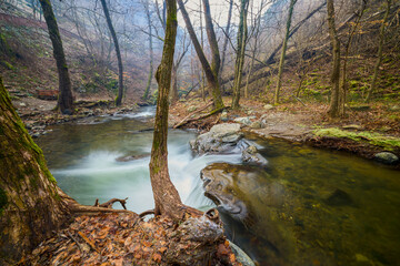 Landscape of the Almaj Valley in Romania, with the watermills of Rudăria and the mountain river.