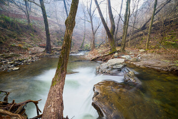 Landscape of the Almaj Valley in Romania, with the watermills of Rudăria and the mountain river.