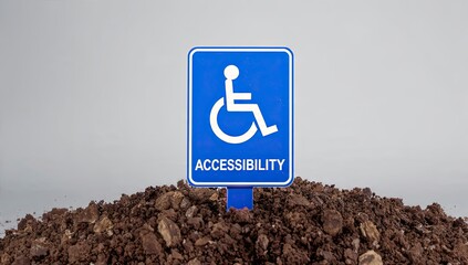 Accessibility Sign on a Pile of Earth: A blue accessibility sign with a wheelchair symbol stands prominently atop a mound of earth, symbolizing inclusivity, equal opportunity.