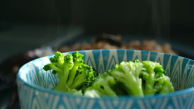 Steamed broccoli presentation, Gourmet presentation of broccoli with delicate steam and lighting effects, Highend plated broccoli in blue vessel showcasing refined aesthetics and gentle steam accents