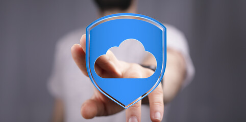 Hand reaching out to a blue shield with cloud logo, representing data protection, cyber security, online safety
