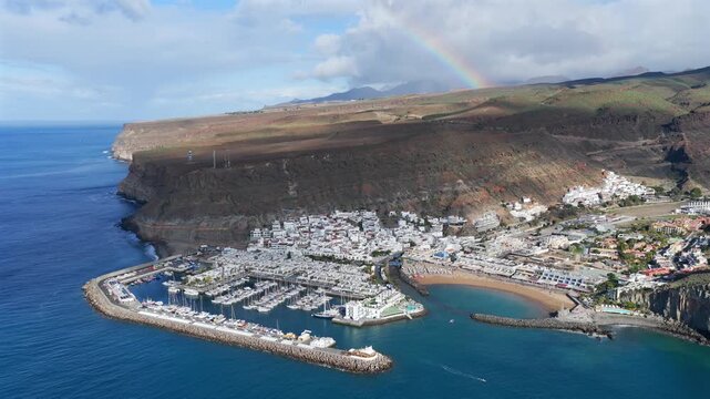 Puerto de Mog&aacute;n Aerial View with Rainbow over the South Coast of Gran Canaria, Canary Islands - 4K Cinematic Shot