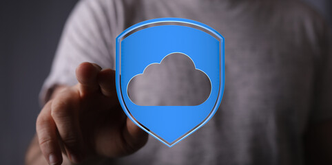 Person pointing at a cloud symbol within a shield, representing secure cloud data storage and online protection
