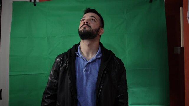 Man wearing a leather jacket posing on a chroma key green screen.