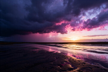 Dramatic Sunset Over Stormy Coastal Beach