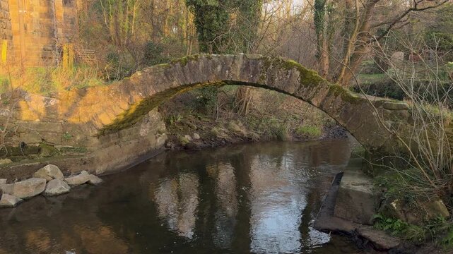 4K: Packhorse Bridge over a stream in England in Winter in the Daytime. Stock Video Clip Footage