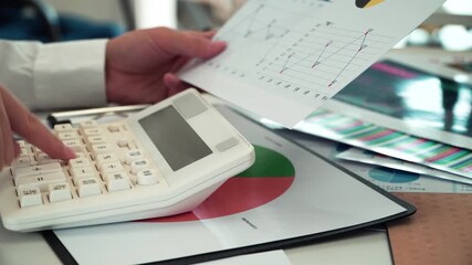 A businessman who analyzes financial statements and checks the data with a calculator - Powered by Adobe