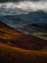 An atmospheric mountainscape unfolds, filled with textured slopes and a misty ambiance. The landscape evokes a feeling of solitude and awe.