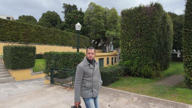 Man standing in garden with trees and pathway
Outdoor portrait of a person in a landscaped garden surrounded by greenery.