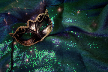 Venetian mask with gold decorations on a shiny background