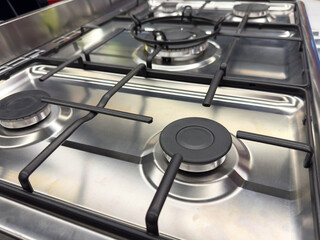Stainless steel gas stove top with four burners in kitchen setting