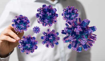 3D render of virus particles near a human hand, symbolising infection, spread and research. Suitable for medic