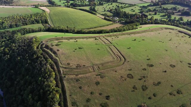 E over Hod Hill Iron Age hillfort. Blackmore Vale, Dorset. Main rampart dates from 500 BC. Once home of the Durotriges. Later Roman fort in NW corner. Video fly back up from Roman fort