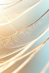 Delicate spiderweb covered in dew drops with soft morning light against a pale blue sky.