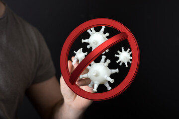 Concept of stopping the spread of viruses and germs. Hand with prohibition sign over the viruses with a dark b