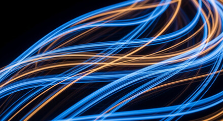 Abstract image of blue and orange light trails on black background, creating dynamic, flowing lines suggesting movement and energy