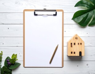 Blank clipboard, pen, wooden house, and plants on white planks creating a simple, clean, inviting space
