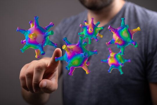 Conceptual image of a person interacting with floating coronavirus particles, symbolizing the presence and spr
