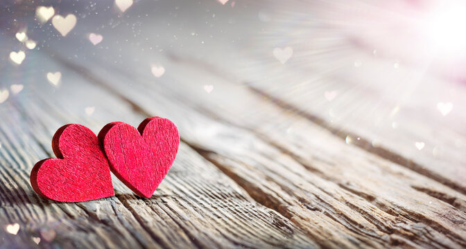Valentines Day - Two Hearts On Wooden Table With Abstract Glittering Of Lights And Flare Effects
