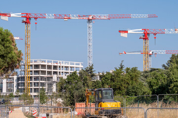 Wide view of construction site with tower crane over building development featuring architecture and urban engineering infrastructure for property project