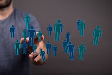 Hand reaching towards a network of virtual people icons, representing teamwork, online connection and the digit