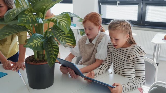 Schoolkids using tablets during biology, science class..