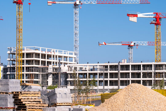 Wide construction site materials stockpile with tower crane and building development showing architecture urban engineering infrastructure property project
