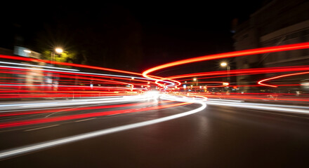 Abstract image of red and white light trails at night, creating dynamic, swirling patterns symbolizing city movement and energy