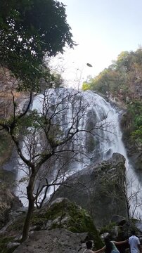 Beautiful Scenic Waterfall Cascading Down Huge Rock Face Tropical Forest Landscape Outdoors Powerful Water Flow Motion Creating Peaceful Atmosphere Nature Serene Refreshing Environment Low Angle View