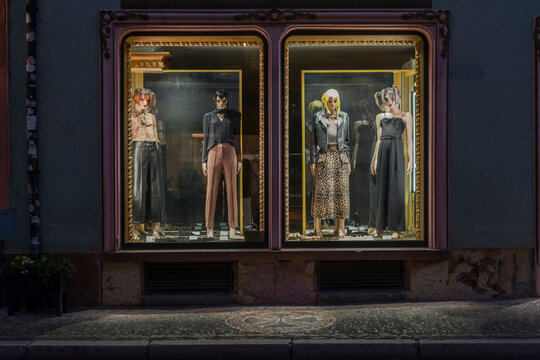 Modegesch&auml;ft in Abendstimmung mit beleuchtetem Schaufenster
