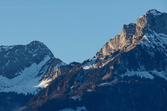 Majestic snow-capped mountains bathed in sunlight, perfect for travel, adventure, and nature themes. - Powered by Adobe