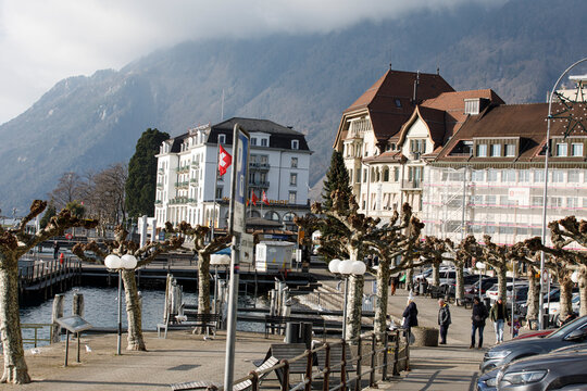 Scenic view of a Swiss town with buildings, lake, and mountains. Winter atmosphere, travel and touri