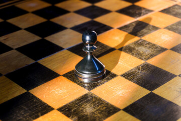 Chess pieces on a board, a black pawn among white pieces, different and special, black moves first,...