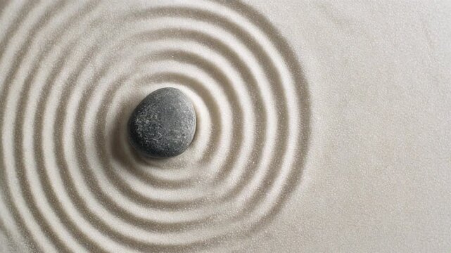 Stone in zen garden with circular sand patterns