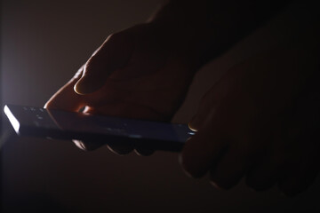 Close-Up of Hands Using Smartphone in Dark Environment - Technology, Communication, and Modern Lifestyle © alexkich