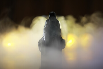Mysterious Cloaked Figure in Foggy Ambiance with Dramatic Lighting