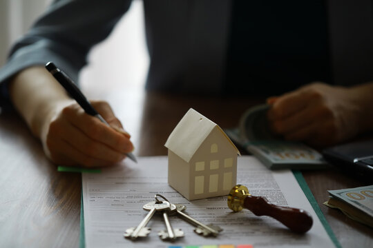Real estate agent talked the terms of the home purchase agreement and asked the customer to sign the documents, Home sales and insurance concept.