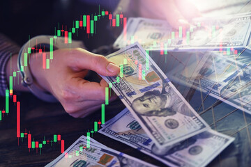 women's handcuffed hands hold dollars. handcuffed hands on a money banknotes background.