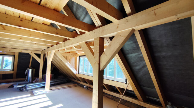 The attic of a house with wooden beams and roof coverings, inside the building.