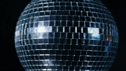 A high-contrast, low-key close-up emphasizes the shimmering silver mirror ball reflecting light, setting a vibrant nocturnal party mood in a dark nightclub setting.