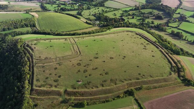 E over Hod Hill Iron Age hillfort. Blackmore Vale, Dorset. Main rampart dates from 500 BC. Once home of the Durotriges. Later Roman fort in NW corner. Video fly down in to Roman fort