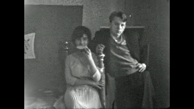 Static portrait, young couple standing in Soviet-era room, looking at camera. Vintage mid-20th century interior capturing domestic life in home indoor. Old film. Archival retro 1970s. Vintage archive