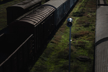Overhead view of vintage freight train cars on railway tracks with green grass and shadow, suitable for transportation and industrial concepts.