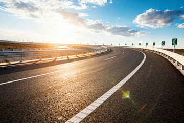 Fototapeta premium Asphalt Highway Curving Under Bright Sun