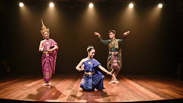 Elegant traditional Thai dance performance in vibrant costumes under stage lighting