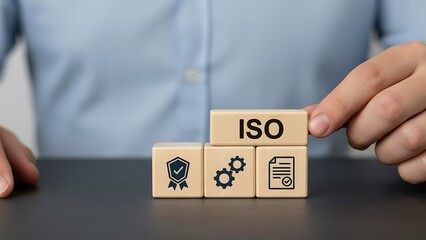 Naklejka premium Businessman placing iso block on top of quality management cubes on a table in office