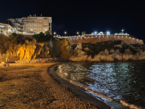 beach night allure, nighttime seaside landscape featuring luminous hotels and reflective sands