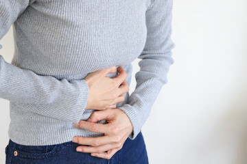 お腹の痛みを感じる女性