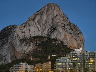 evening city contrast, dusk illuminates cityscape contrasting with mountain silhouette and night sky